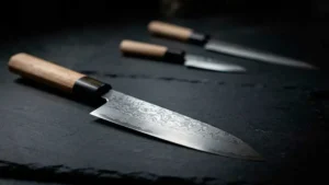 Cuchillos Deba de diferentes tipos sobre una tabla de cortar oscura