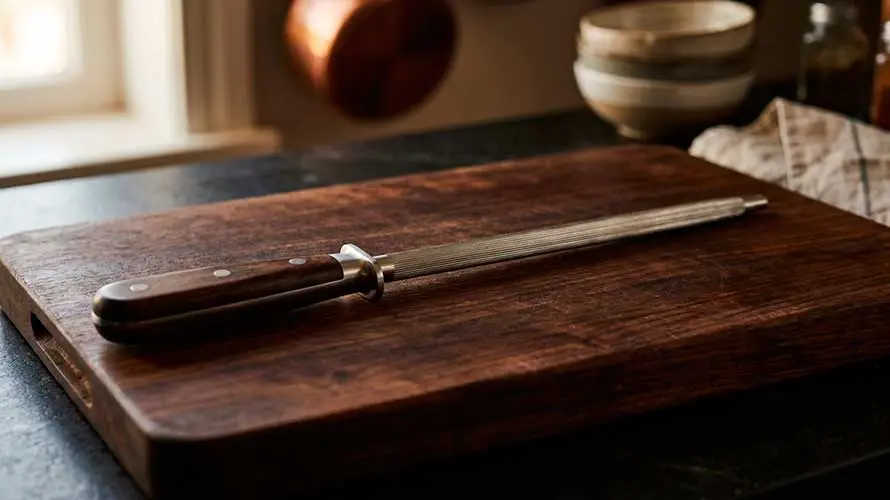 Chaira sobre una tabla de corte de madera oscura en una cocina