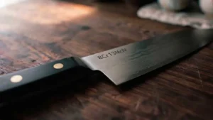 Cuchillo de acero 8Cr13MoV sobre tabla de corte de madera