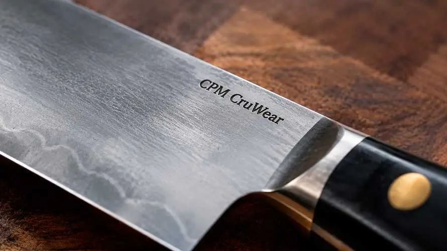 Cuchillo de acero CPM CruWear sobre una tabla de corte de madera