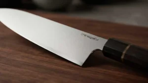 Cuchillo de acero CPM Magnacut sobre una tabla de corte de madera