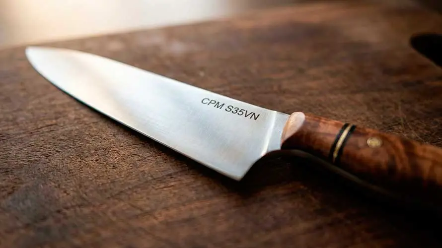 Cuchillo de acero CPM S45VN sobre una tabla de corte de madera