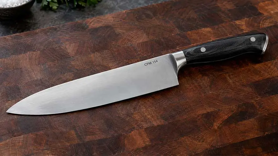 Cuchillo de acero CPM 154 sobre una mesa de madera de roble oscuro